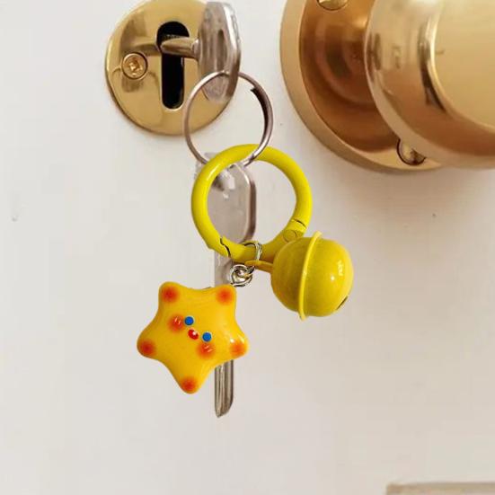 Schlüsselanhänger mit lächelndem Stern und Glöckchen, leicht, ideal als Geschenk für Freunde und Paare.