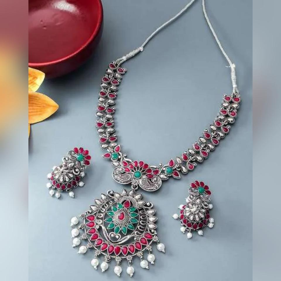 

Посеребренное колье и серьги с каменными заклепками