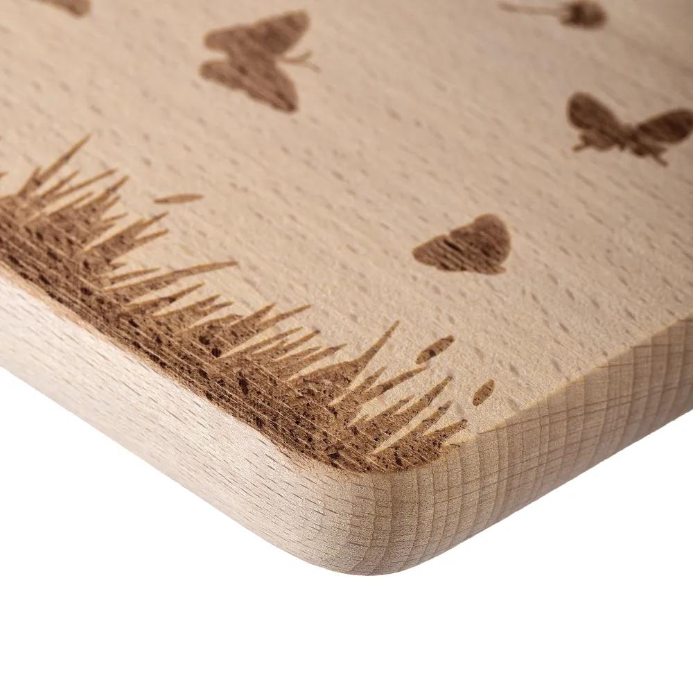 Wooden cutting board with an engraved meadow