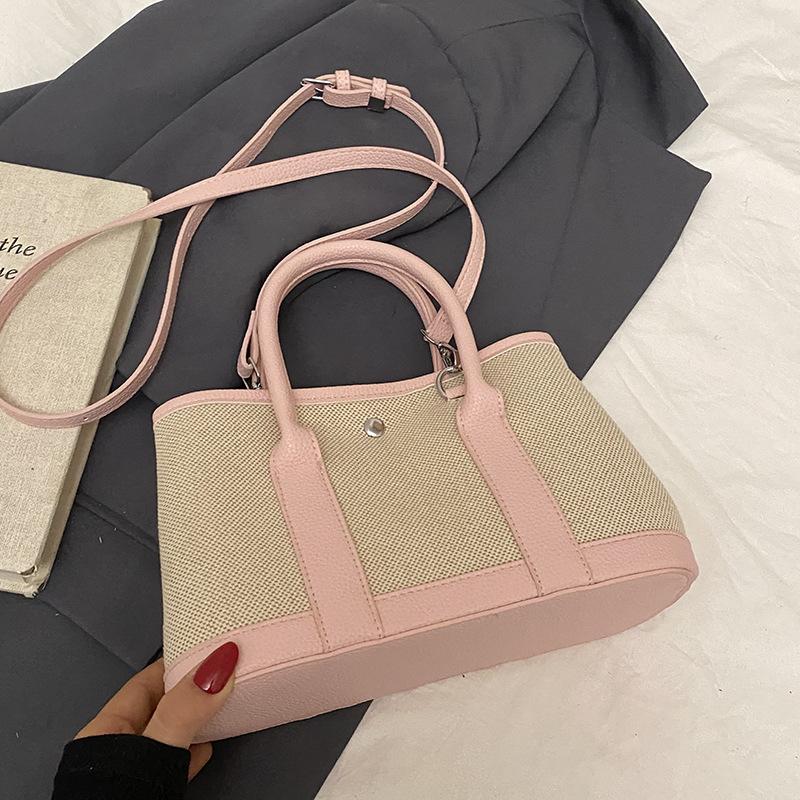 Spring new fashion contrasting color splicing portable bucket bag women's leisure work commuter wind messenger letter bag