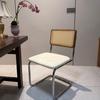 Elegantly crafted armless rattan dining chair in retro pastoral style, perfect for cafes, guesthouses, and vintage settings.