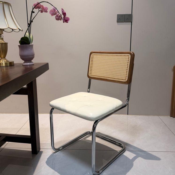Elegantly crafted armless rattan dining chair in retro pastoral style, perfect for cafes, guesthouses, and vintage settings.