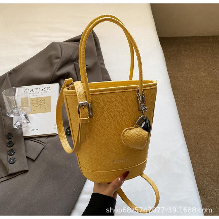 New niche simple solid color lychee pattern texture hand carrying bucket bag versatile foreign style commuting messenger women's bag