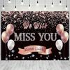A photo backdrop for a retirement farewell celebration featuring a rose gold banner that reads "We will miss you"