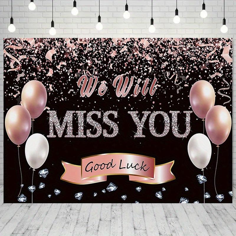 A photo backdrop for a retirement farewell celebration featuring a rose gold banner that reads "We will miss you"