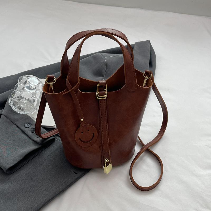 

Нишевая ретро сумка через плечо женская летняя новая портативная сумка-ведро с продвинутой текстурой, универсальная сумка-мессенджер для通勤, женская сумка коричневый