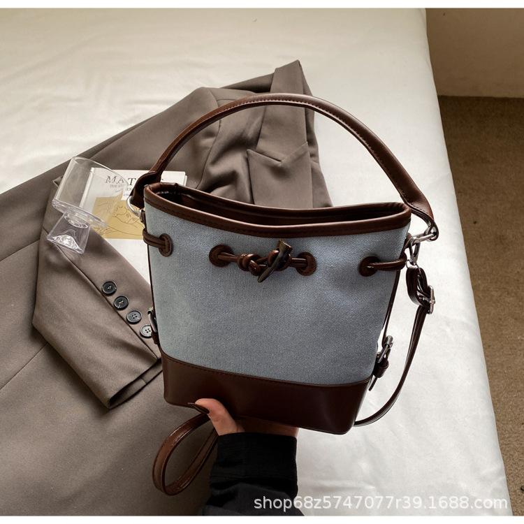 2025 new niche design canvas portable bucket bag women's simple high-end commuter shoulder messenger women's bag