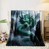 A green, serpentine dragon with glowing eyes emerges amidst misty cliffs. for all seasons blanket lunch break throw gift