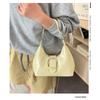 Solid color crescent-shaped hobo bag with metal D-ring embellishment, elegant underarm bag, versatile women's handbag for dates and everyday wear.