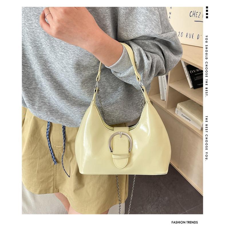 Solid color crescent-shaped hobo bag with metal D-ring embellishment, elegant underarm bag, versatile women's handbag for dates and everyday wear.