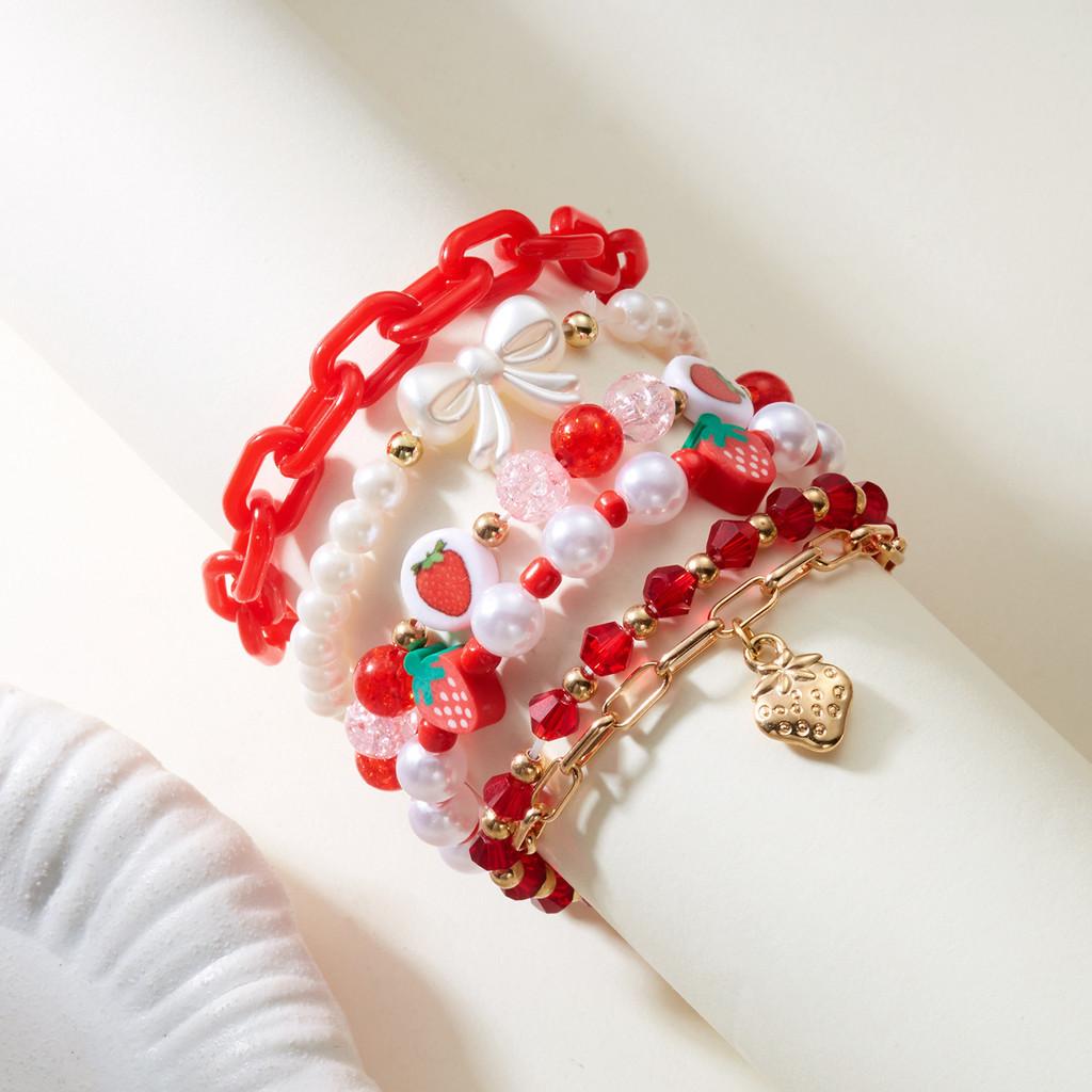 Schattige cartoonarmband met aardbei-harthanger en harskralen, ideaal als cadeau of reissouvenir.