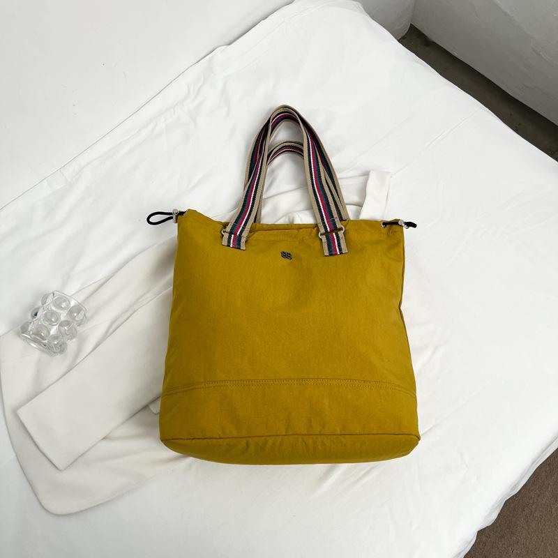 

Solid color travel Huacai department student bag make-up class messenger bag casual versatile large-capacity shoulder cloth bag темно-жовтий колір