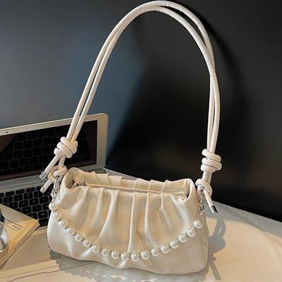 Eine trendige und ausgefallene Tasche mit plissierten Wolken Eine trendige Achseltasche und eine Umhängetasche mit einem Schulterriemen