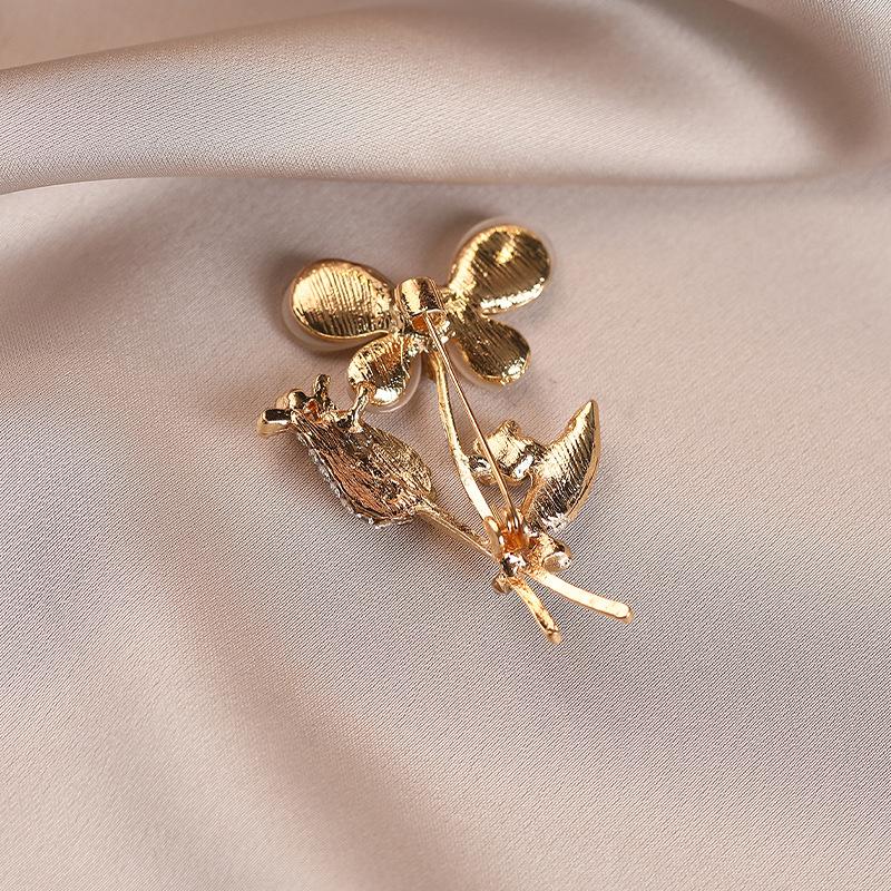 Eine blumige Brosche von leichtem Luxus mit einer hochwertigen femininen Note, eine Nischenanstecknadel, ein raffinierter Anzugmantel und eine exquisite Korsage