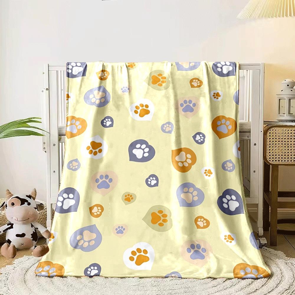 Paw prints inside heart shapes in pastel tones on a yellow background. for all seasons blanket lunch break throw gift 80cm x 120cm