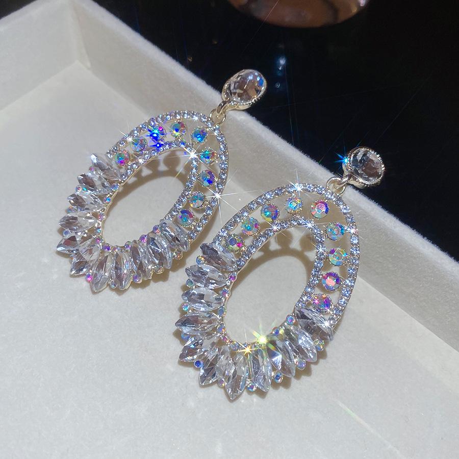 Геометрические овальные серьги с инкрустацией стразами  Серебряная игла : Элегантные и стильные серьги-гвоздики с ноткой роскоши.