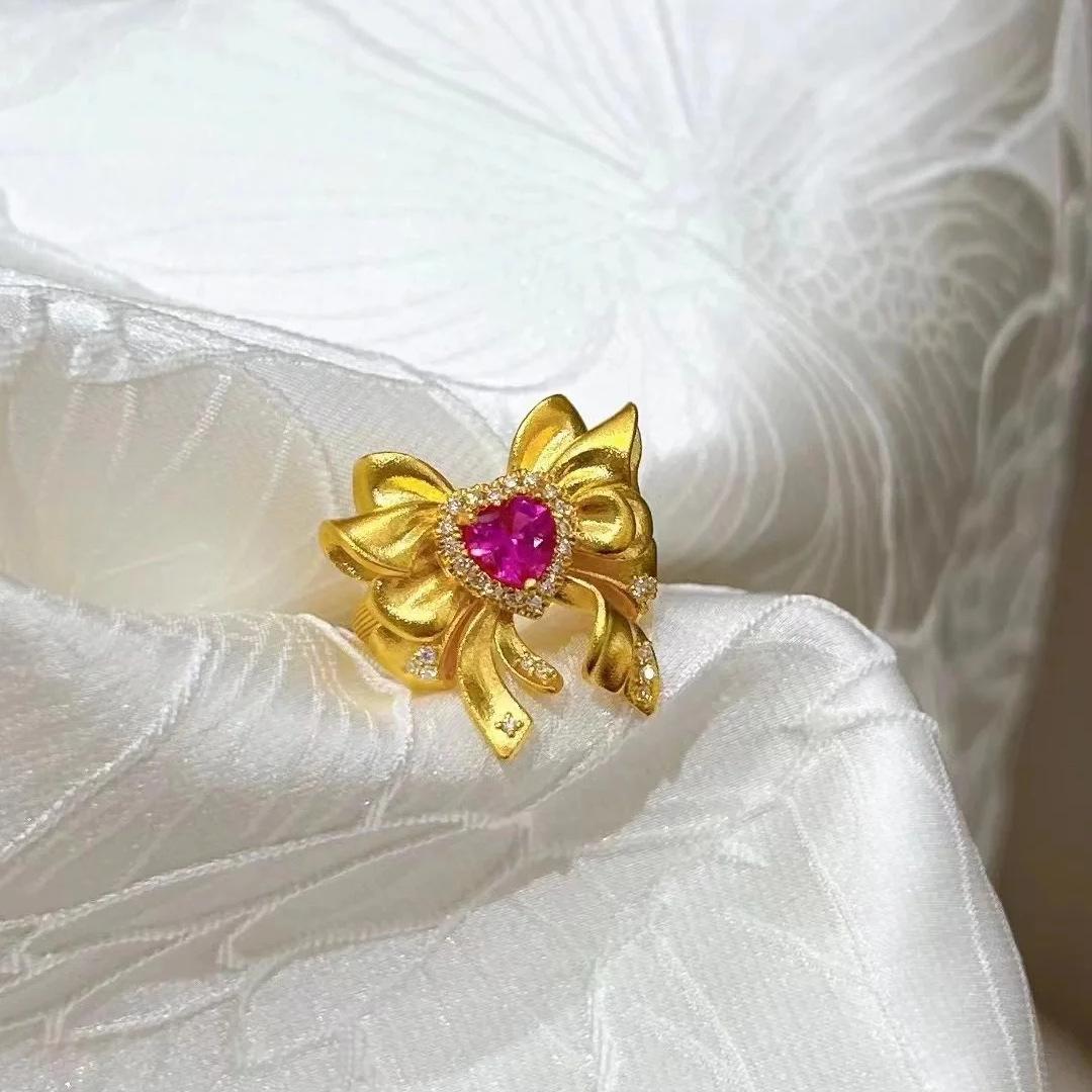 Передовое гальваническое покрытие Древнее золото песка Имитация красного бриллианта Кольцо любви с бантом Женская красота Девушка Вода Лед Луна Живое кольцо