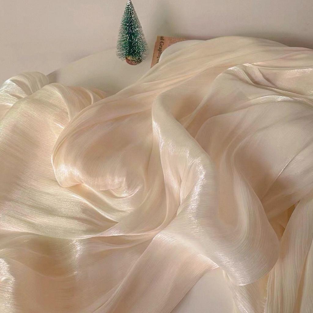 Soft shiny creased organza fabric with a smooth texture suitable for wedding dresses formal gowns and designer clothing fabrics