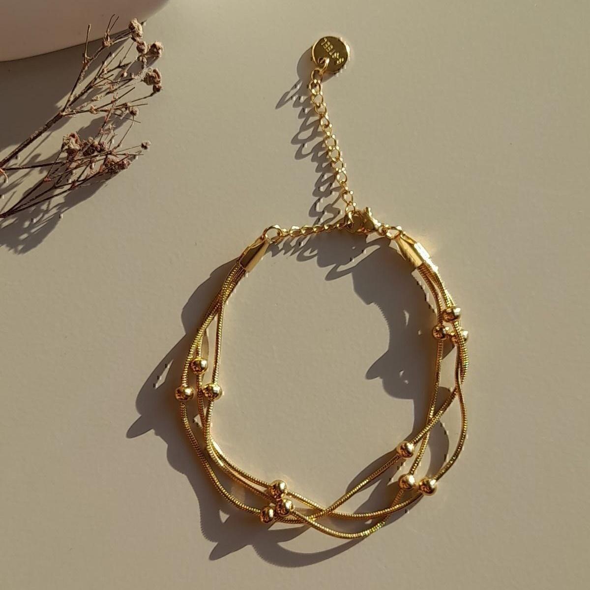 

Жіночий сталевий браслет Dorika з потрійним ланцюжком зі змійкою золотого кольору