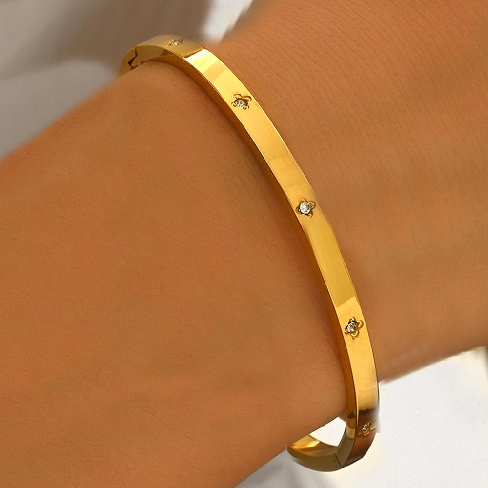 Gold Heart-Shaped Stainless Steel Bracelet with Embroidered Bow and Tassel Woven Cord.