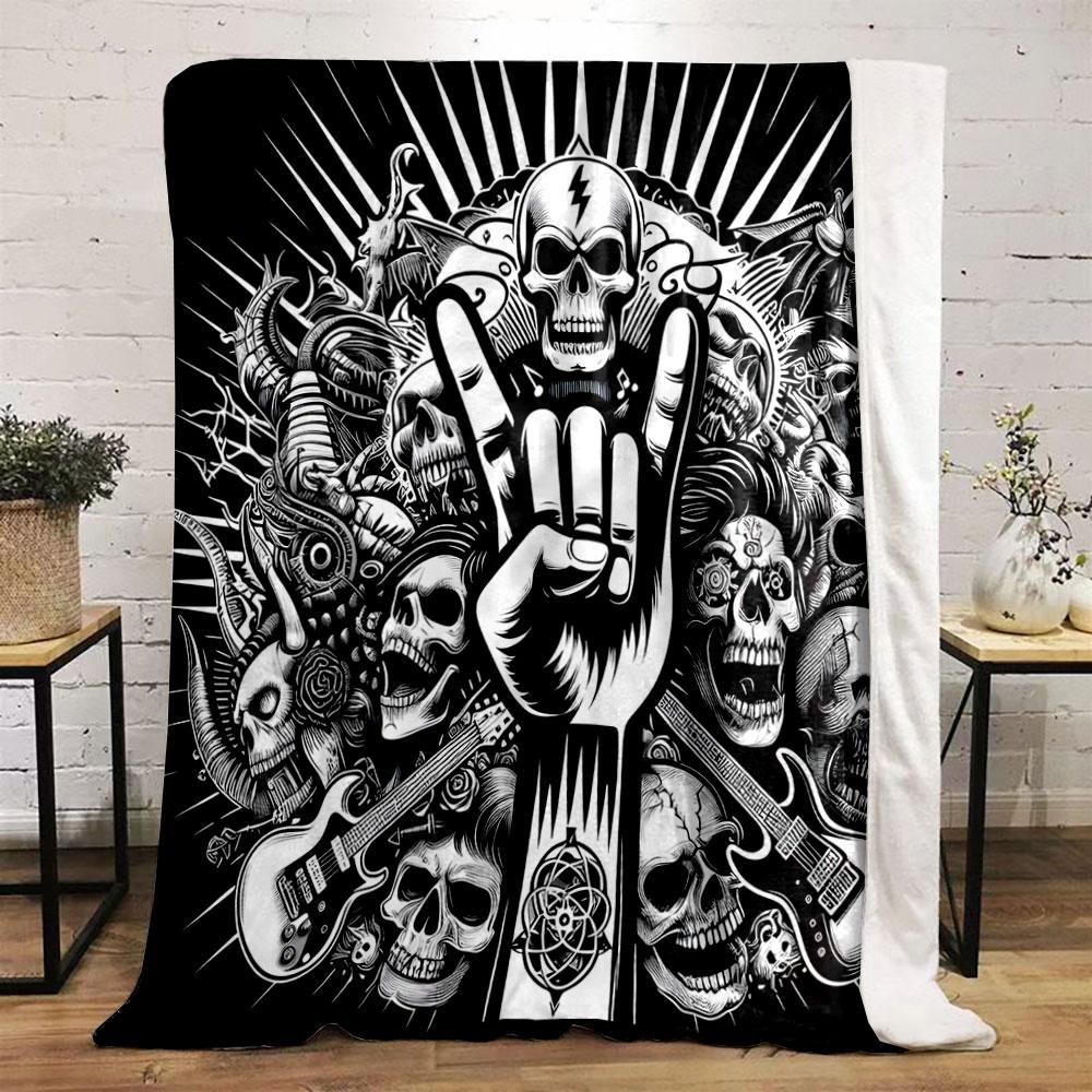 A skull-heavy design with a "rock on" hand gesture, guitars, and dark motifs. for all seasons blanket lunch break throw gift
