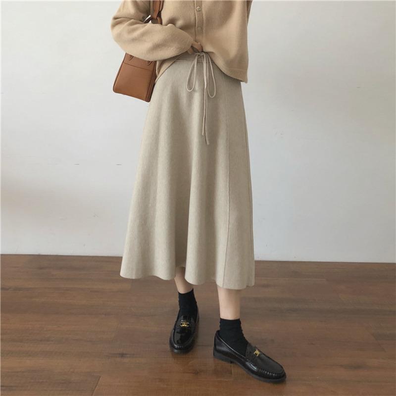 Podzimní a zimní pletená vlněná sukně střední délky áčkového střihu s vysokým pasem a vsadkami ze síťoviny