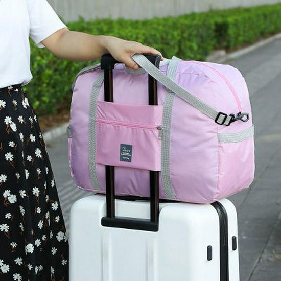 Compact travel bag: suitcase-compatible, hand-held, features an external pocket, handle slip-over design, with matching accessory bag.