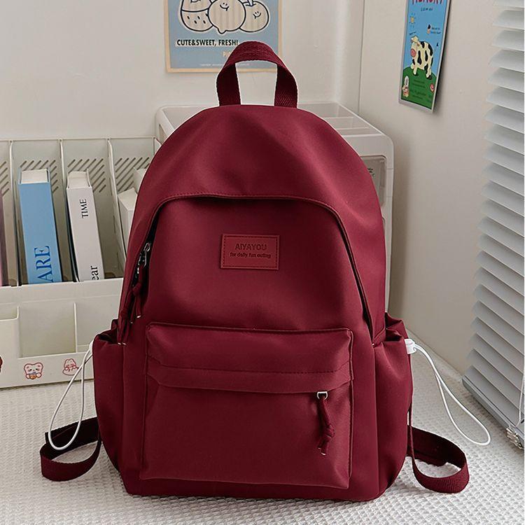 

Simple and versatile schoolbag, junior high school student campus backpack, large-capacity college student Korean version, solid color backpack pink. With pendant червоний
