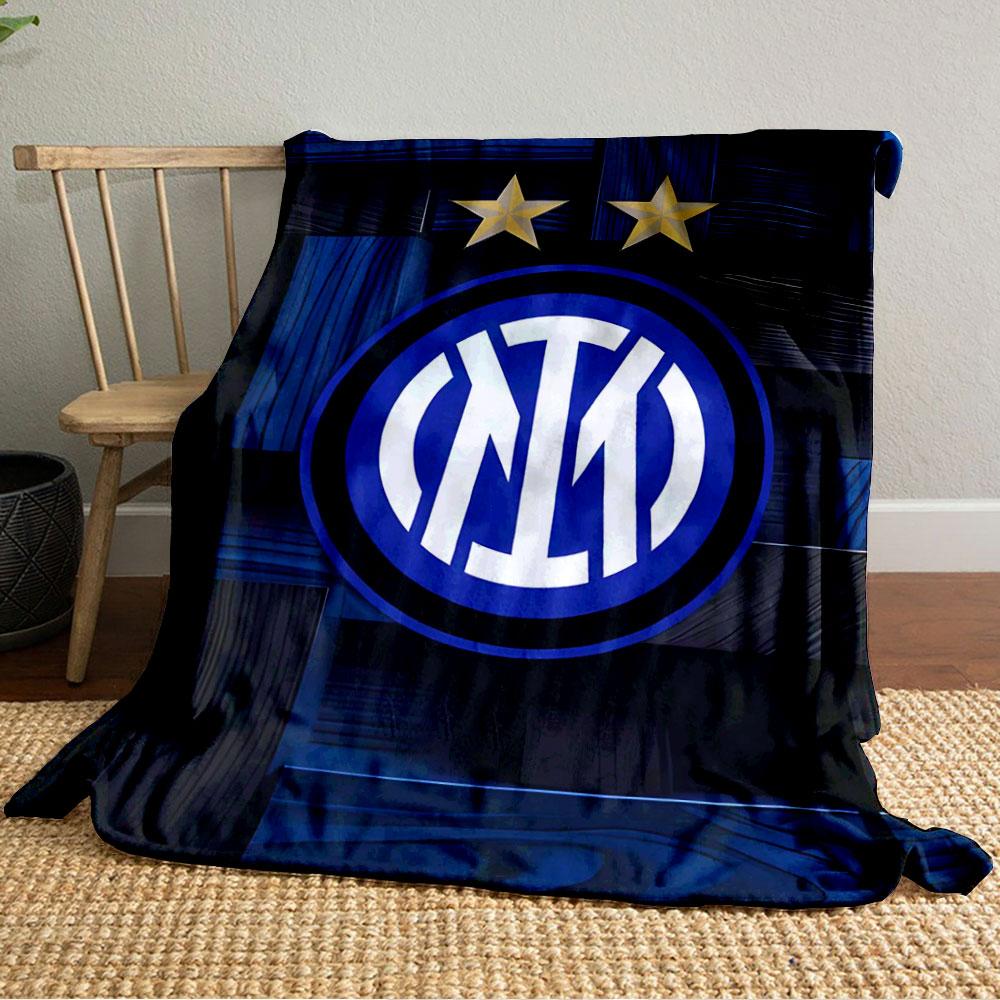 Intertwined white letters in a blue circle, two gold stars above, wood-like background. for all seasons blanket lunch break throw gift