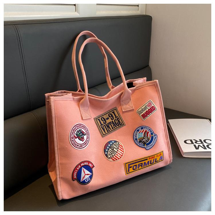 

Large capacity canvas bag 2025 new badge embroidery bag South Korea CIC Harajuku student versatile shoulder tote bag 40*18*31 розовый
