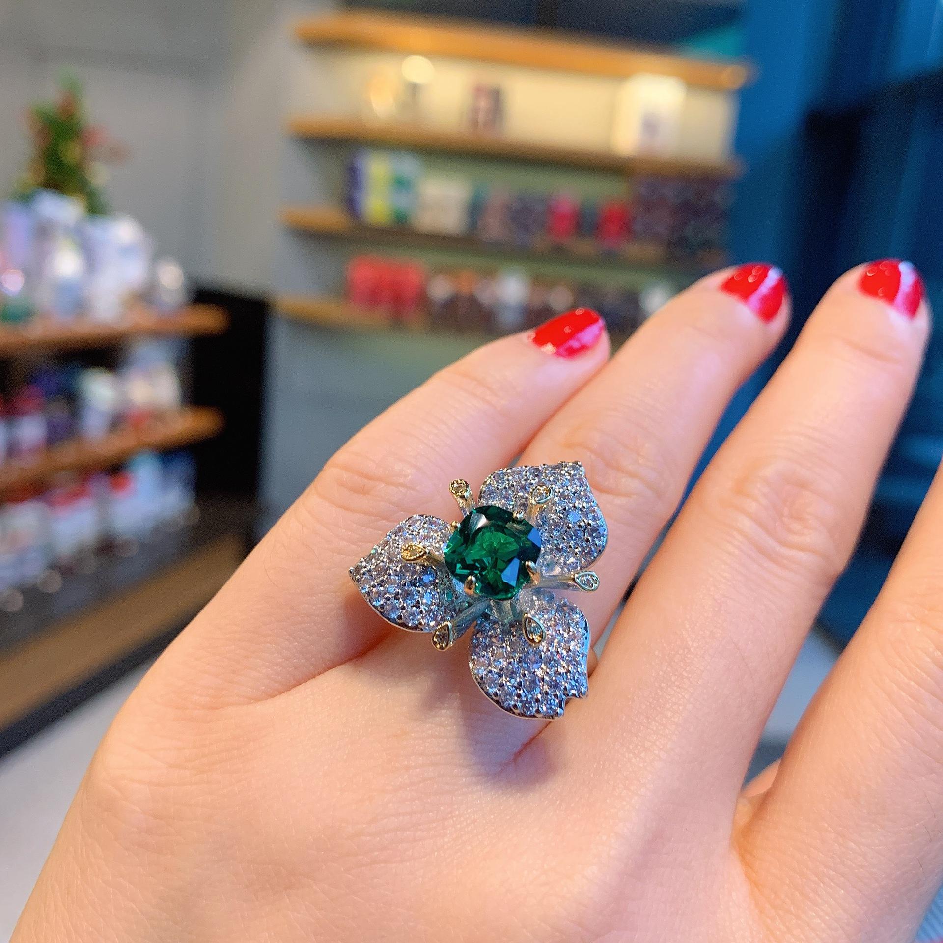 

Кольцо с трехмерной имитацией изумруда и циркония, а также серьги-гвоздики с тремя лепестками из красного корунда и циркония