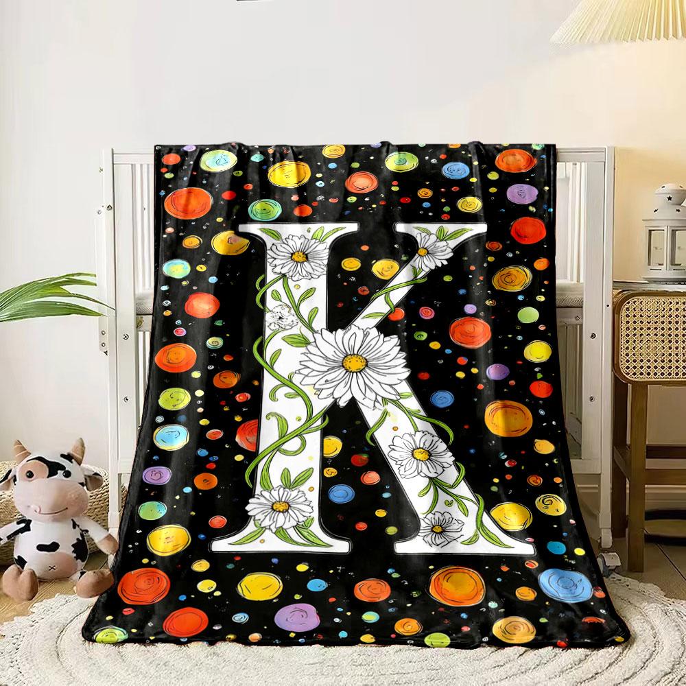 

A floral letter K surrounded by colorful, swirling dots on a black background. for all seasons blanket lunch break throw gift 80cm x 120cm