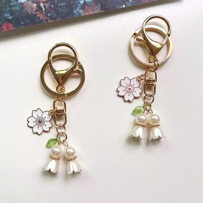 Krásný přívěsek na klíče Konvalinka zlaté barvy kovová spona ozdoba dámské kabelky elegantní květinové klíčenky