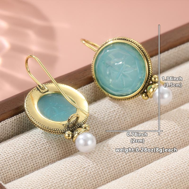 

Изящные серьги-подвески из металла золотистого цвета, круглые, инкрустированные камнями цвета морской волны и искусственным жемчугом. золотой