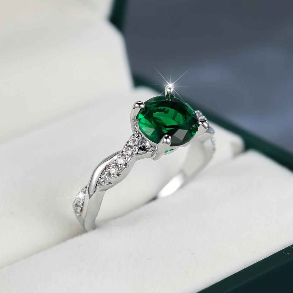 

Толстое белое кольцо K с круглым белым бриллиантом и зеленым бриллиантом