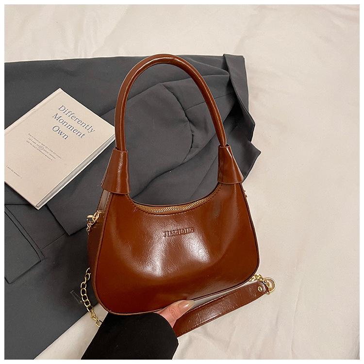 Fashion birth girl small bag 2025 new patent leather design sense portable crescent bag hand carry niche unique underarm bag