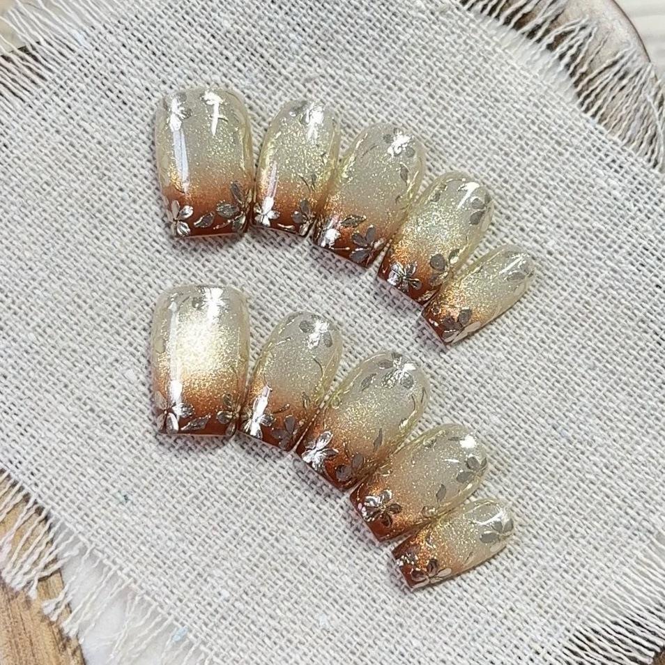 

Brownish-Red Gradient Cat Eye Press-On Nails with Gold Glitter and Floral Design