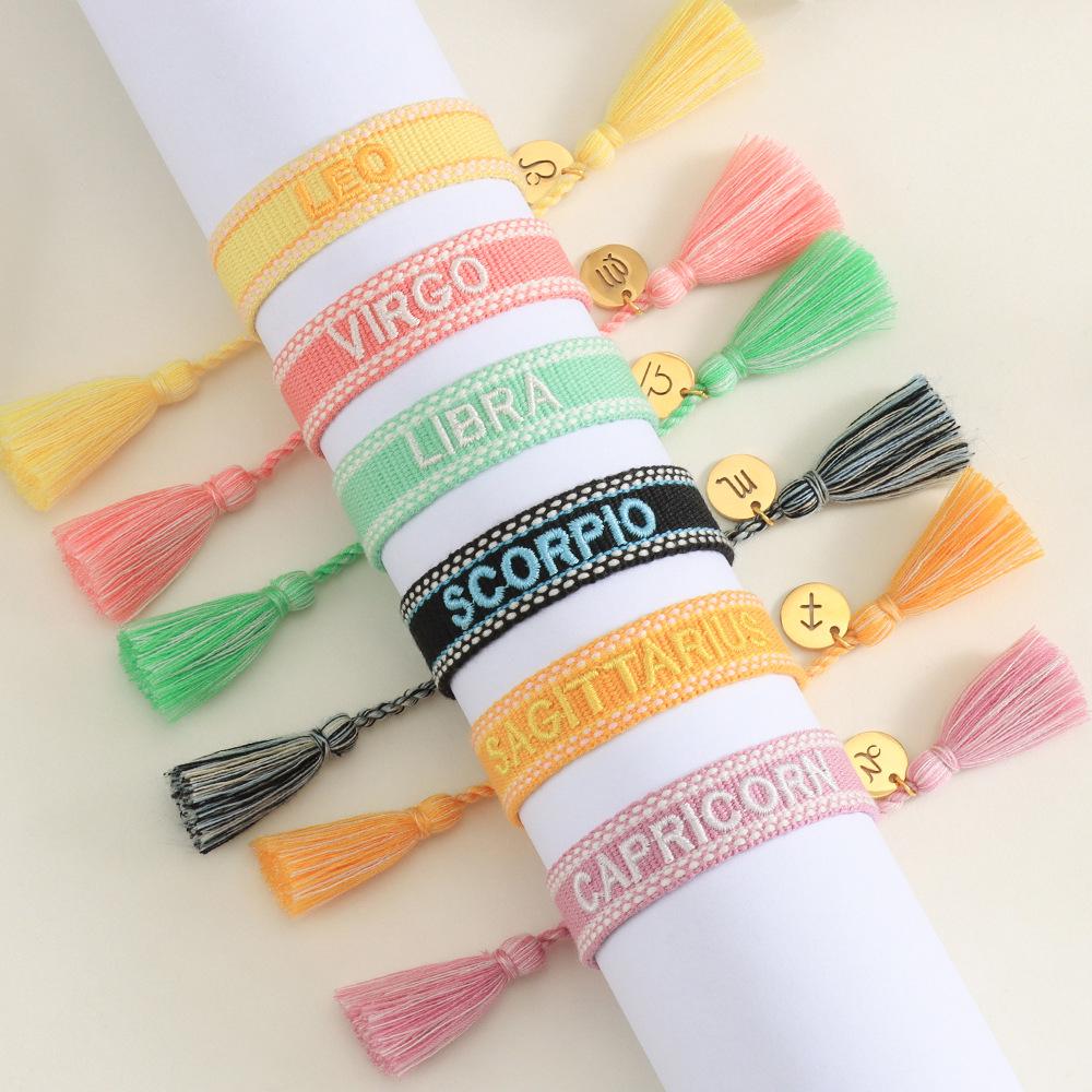 Kreuz Zwölf Sternzeichen Armband: Personalisierte handgefertigte geflochtene Kordel mit bestickten Buchstaben und Sternbild-Anhänger.