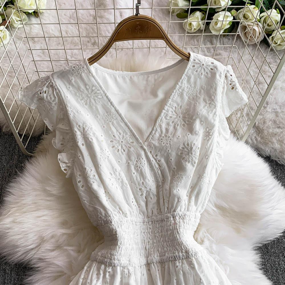 Ein Damen Urlaubsstrandkleid mit einem hohlen V-Ausschnitt, hoher Taille und Flatterärmeln, das schlank macht.