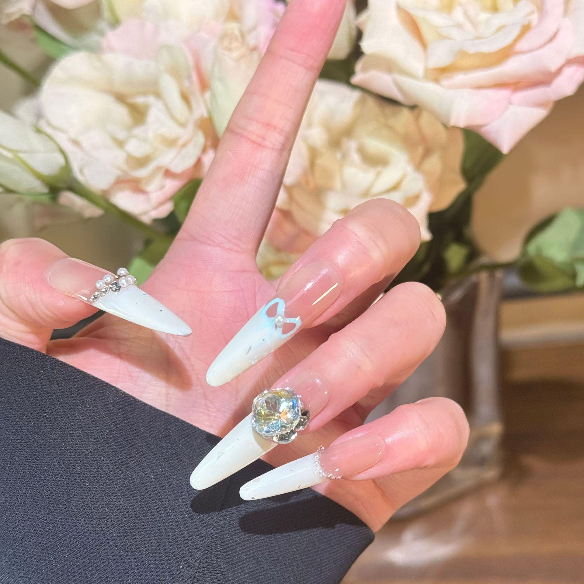 

Французский маникюр, расписанный вручную: Молочно-белый с блестками, дроблеными бриллиантами, жемчугом и крупными бриллиантовыми акцентами.