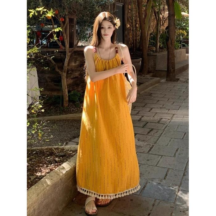 Beach vacation wind yellow fringed suspender dress women's summer 2026 new temperament loose A-shaped long skirt