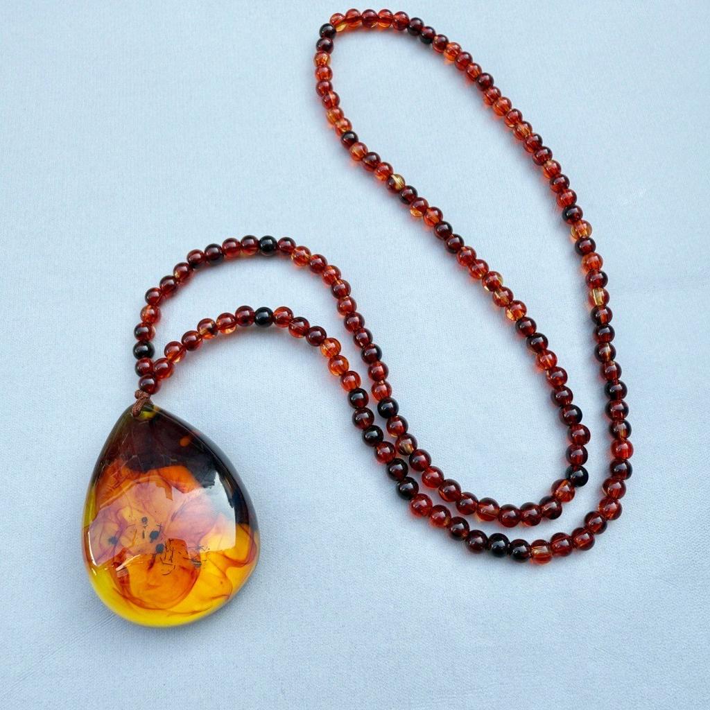  Bursztynowy Vintage Bursztynowy Wisiorek Naszyjnik Wiszący Dla Mężczyzn I Kobiet Z Krwistoczerwonymi Perłami. Naszyjnik Spokojny Urok na Łańcuszku w Etnicznym Swetrze.