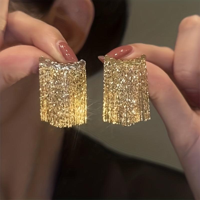 

Модные серебристые серьги-иглы с эффектными изогнутыми кисточками — подчеркните свой стиль