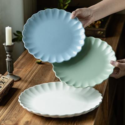 Enkel ensfarget blomsterformet rillet tallerken Høyverdig vestlig mattallerken Keramisk stor tallerken Husholdning rund tallerken Servise tallerken