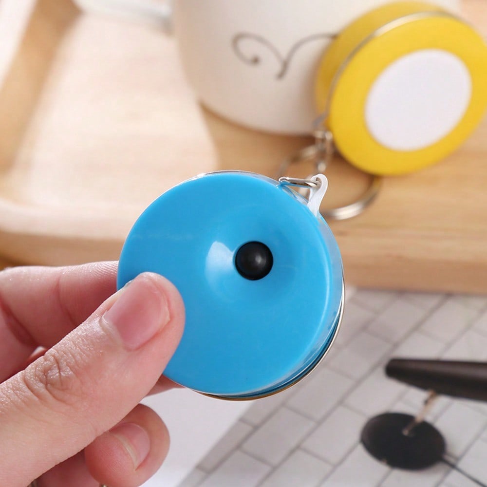 A Stylish Keychain Measuring Tape In Vibrant Colors, Featuring A 1.5-Meter Retractable Design, Perfect for Measuring Clothing Sizes