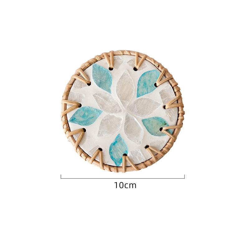 The hand - made rattan - edged shell coasters add a unique marine style to the tabletop.