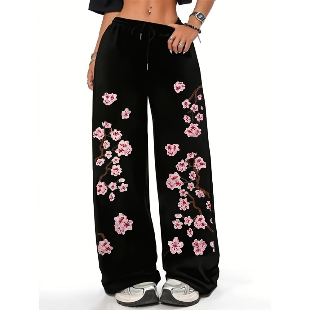 Women's black and pink jogging pants with a cherry blossom print inspired by Japanese floral designs