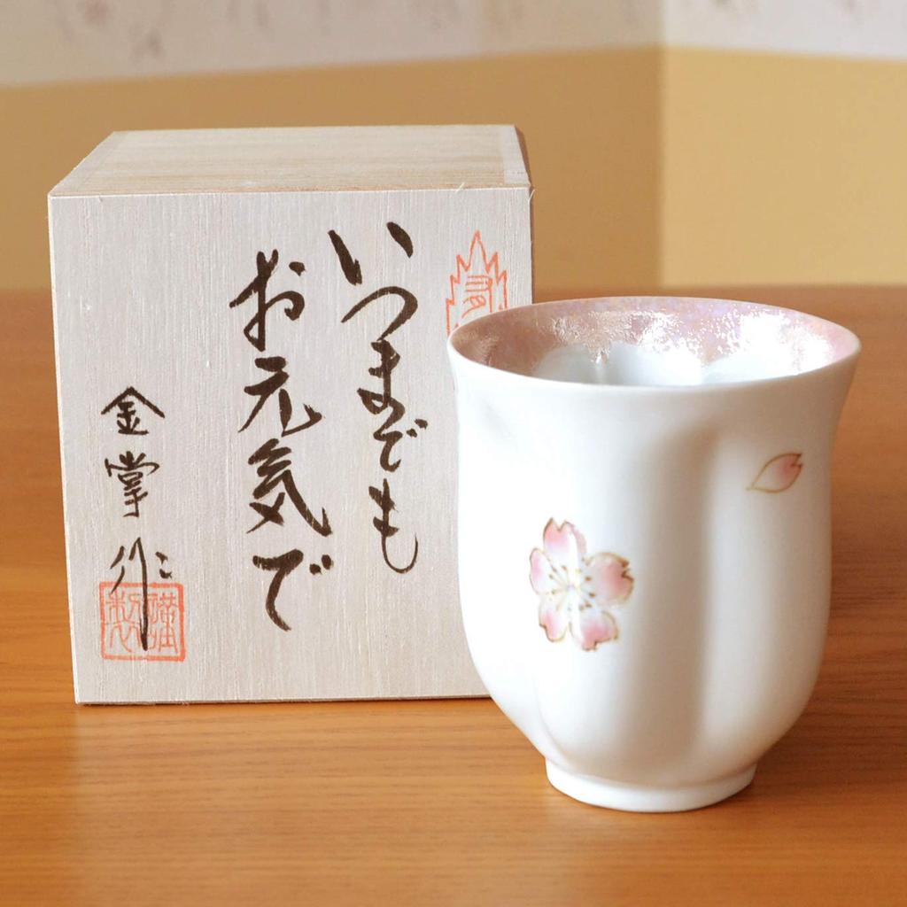 A perfect gift for a 100th birthday celebration for This Arita ware blossom petal comes in a pink and includes a message card and a wooden women.
