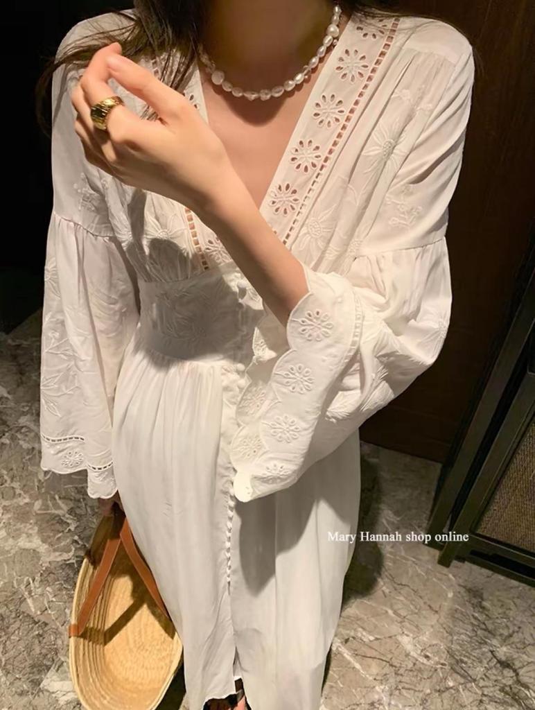 Robe blanche à manches longues et broderie ajourée pour les vacances à l'île ou à la plage