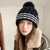 Tide ins ear protectors show the face, cute wool ball, black and white striped knitted hat for women's winter, autumn and winter, new models to keep